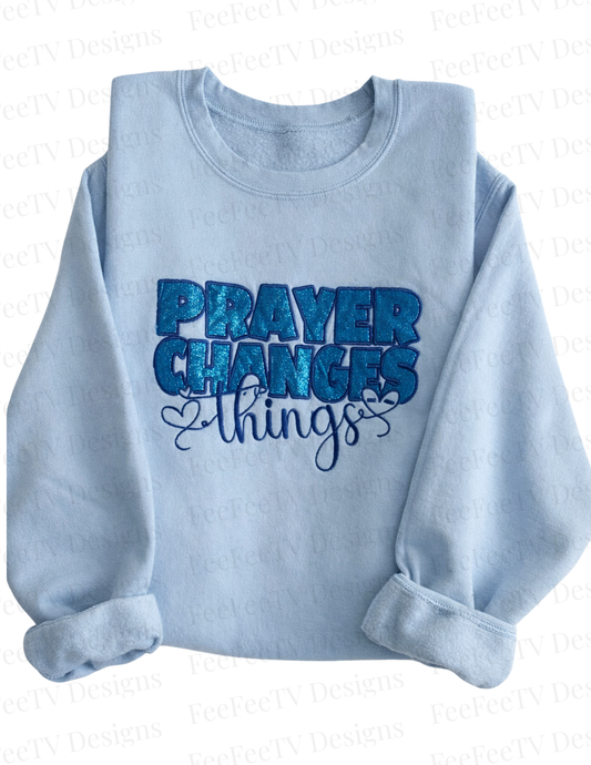 Light blue sweatshirt with 'PRAYER CHANGES THINGS' text on a white background